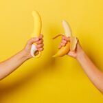 hands holding a banana and a sex toy