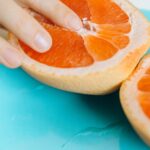 person touching sliced orange fruit